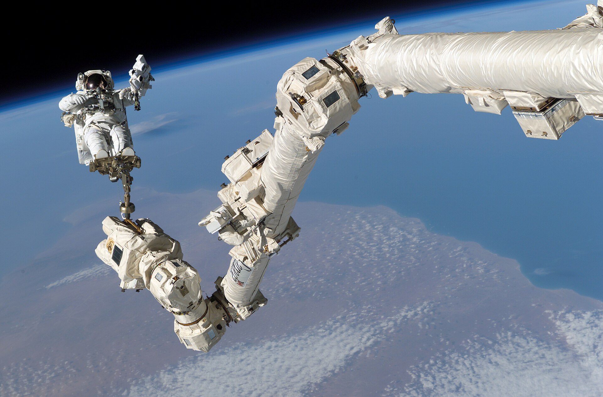 Astronaut on the Canadarm2 robotic arm in space
