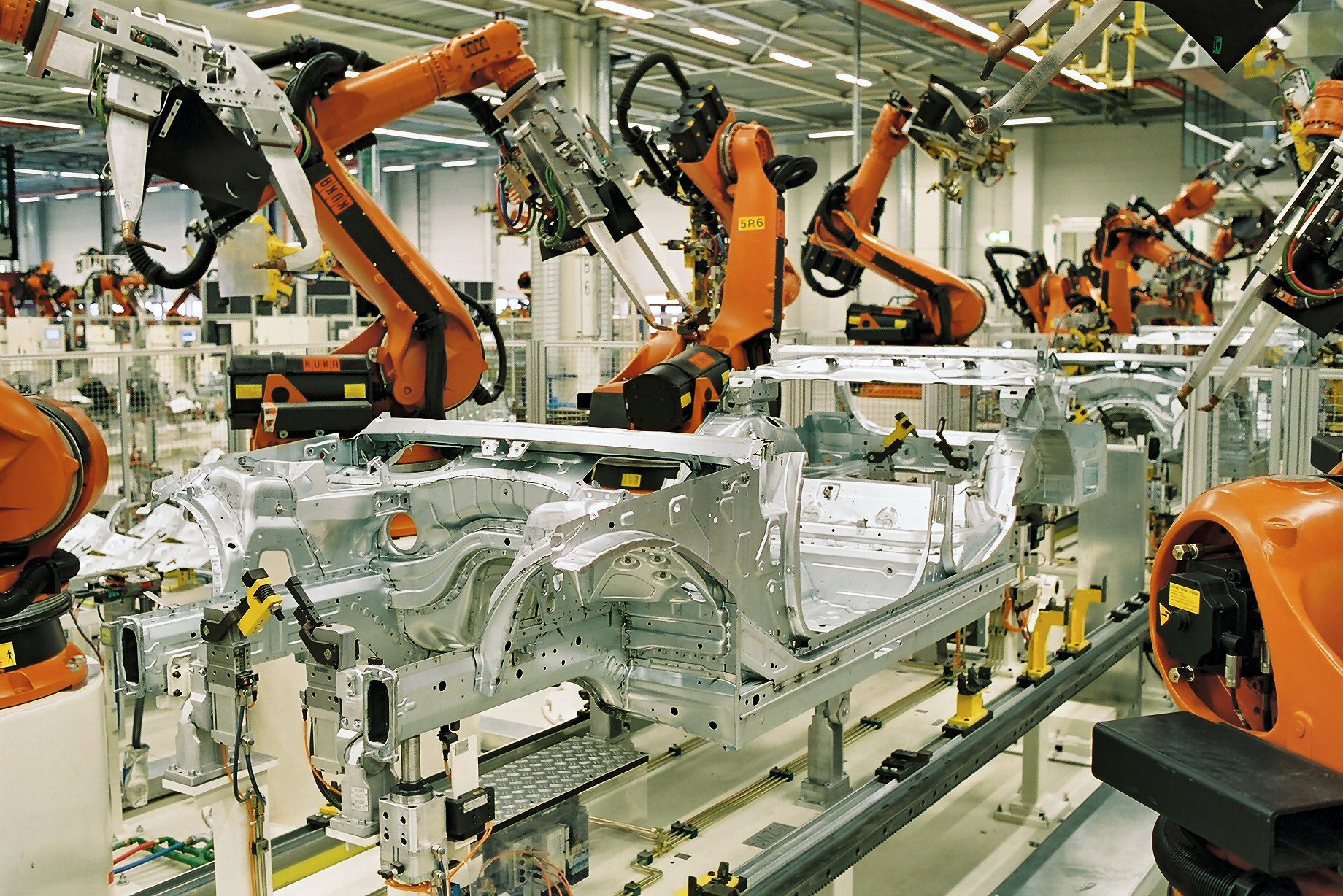 Industrial robots building car bodies in a factory