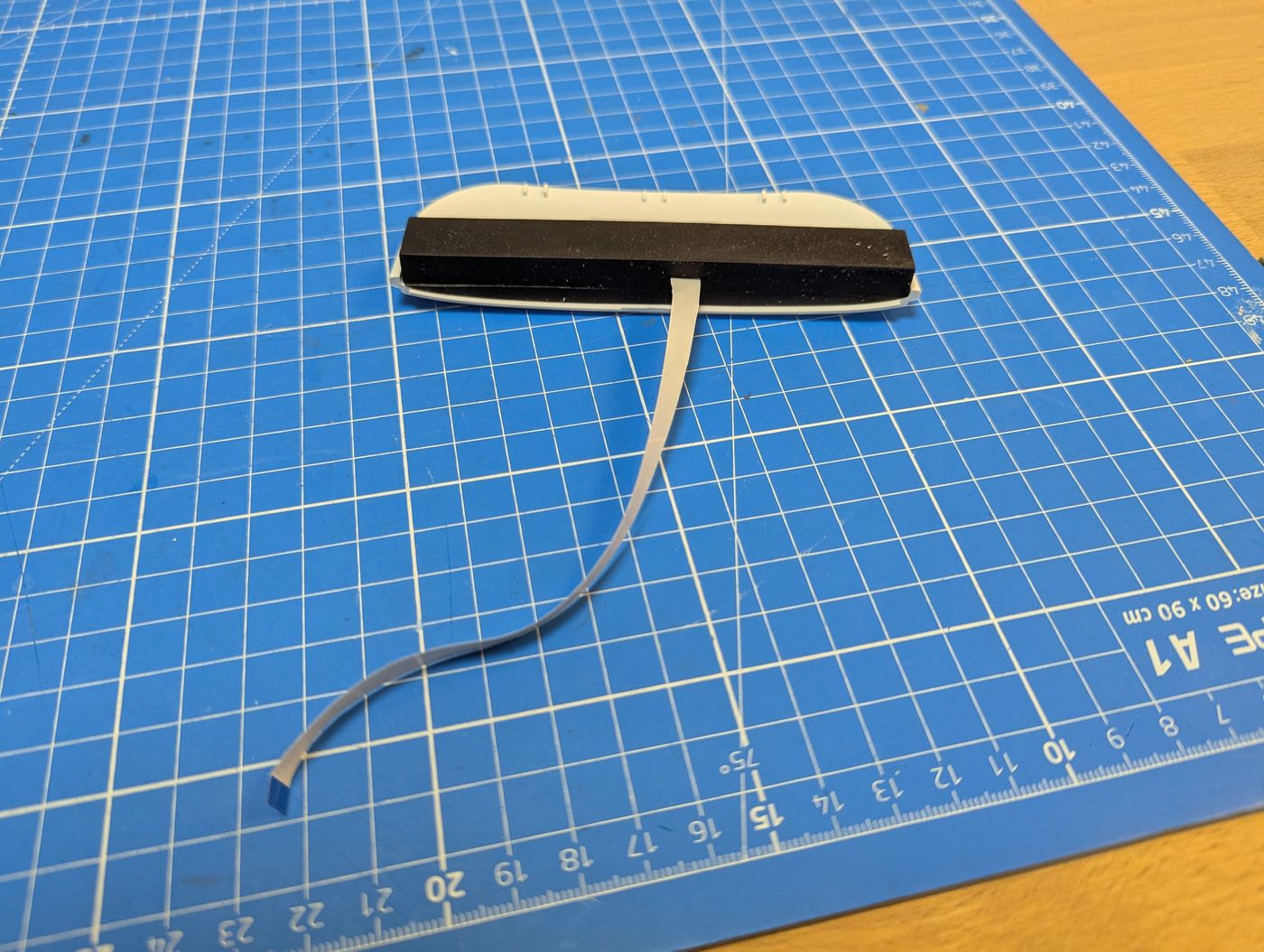 Reachy Mini microphone array board on a cutting mat with ribbon cable